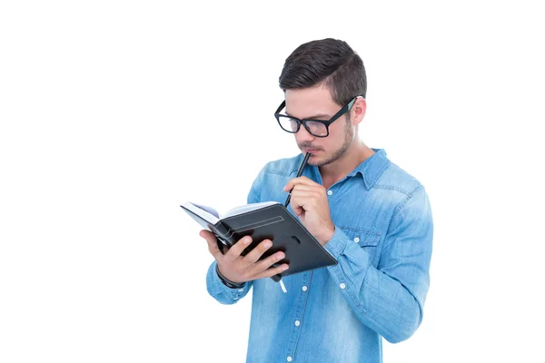 Geeky hipster holding boek en pen — Stockfoto