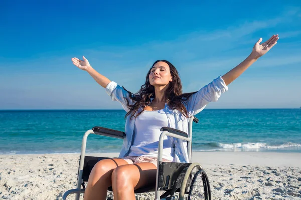 Женщина-инвалид с протянутыми на пляже руками — стоковое фото
