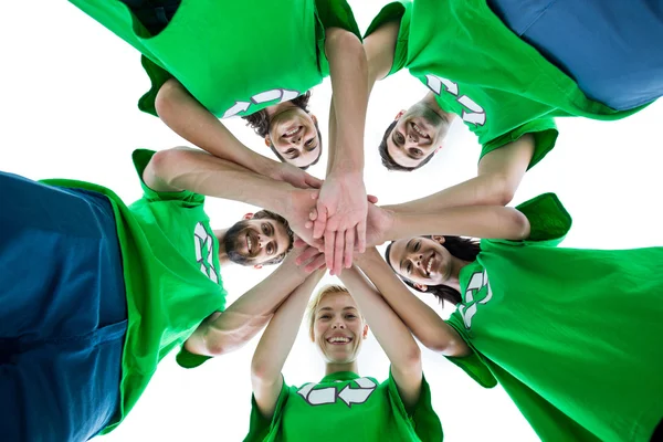 Amigos vestindo camisetas de reciclagem colocando suas mãos juntas — Fotografia de Stock