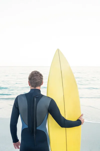 Man in wetsuit with a surfboard on a sunny day — Stock Photo, Image