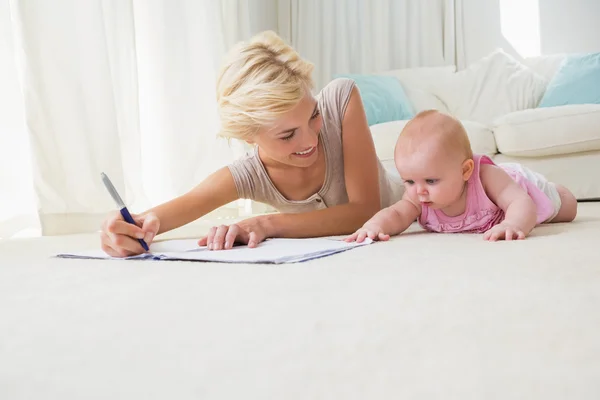 Mother with baby girl writting on copybook — Stok fotoğraf