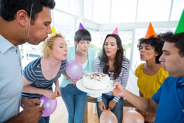 Zakelijke team blazen kaarsen op een verjaardag cake — Stockfoto