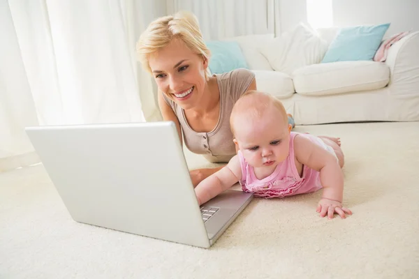 Mother with baby girl using laptop — 图库照片