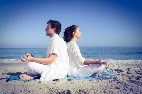 Mutlu çift su yanında yoga yaparken — Stok fotoğraf