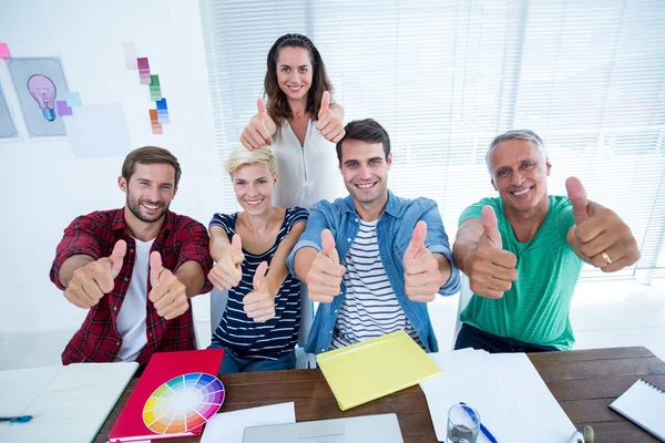 Equipe de negócios criativa gesticulando polegares em reunião — Fotografia de Stock