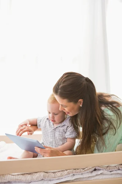 Mutter benutzt Tablette mit Baby — Stockfoto