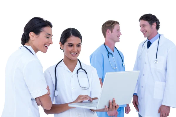 Artsen en verpleegkundigen bespreken en met behulp van laptop — Stockfoto