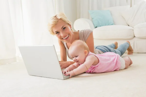 Mother with baby girl using laptop — Stockfoto