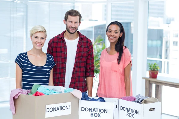 Leende unga vänner volontärer separera kläder — Stockfoto