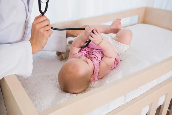 Baby girl with doctor using stethoscope — Stock fotografie