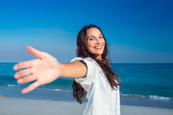 Lycklig kvinna ler mot stranden — Stockfoto