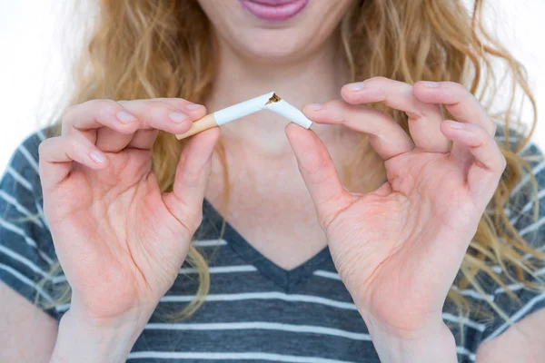Una mujer rubia rompiendo un cigarrillo — Foto de Stock