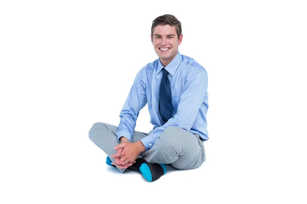 Hombre de negocios sonriente sentado en el suelo — Foto de Stock