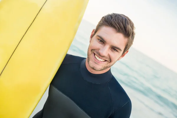 Man in wetsuit with a surfboard on a sunny day — Stock Photo, Image