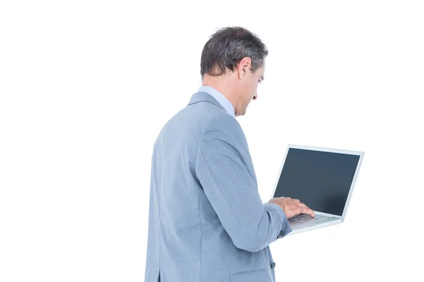Upphetsad jublande affärsman sitter med sin laptop — Stockfoto