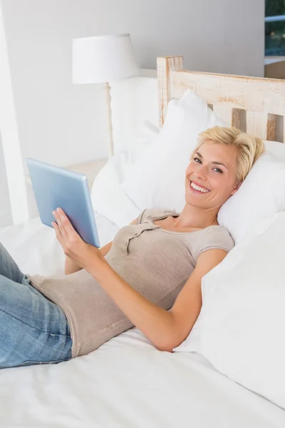 Smiling blonde woman using tablet — Stock Photo, Image