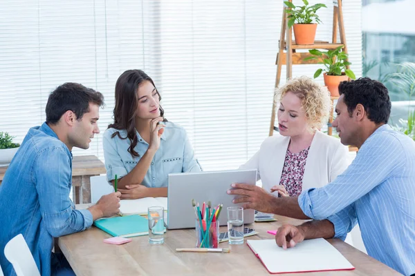 Groep van jonge collega's met behulp van laptop in een vergadering — Stockfoto