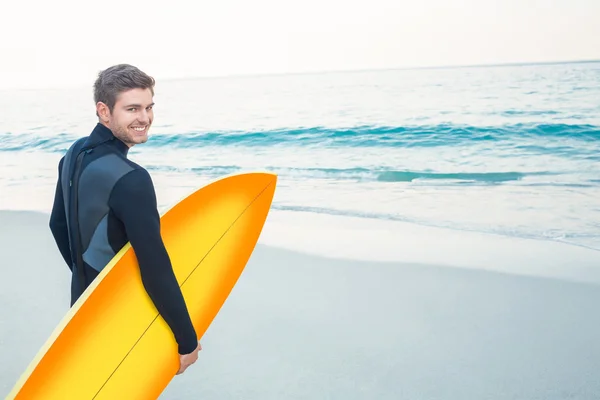 Hombre en traje de neopreno con una tabla de surf en un día soleado —  Fotos de Stock