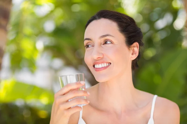 Mulher de branco tendo um copo de água — Fotografia de Stock