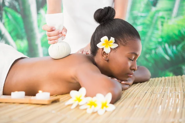 Woman enjoying herbal compress massage — Stock Photo, Image