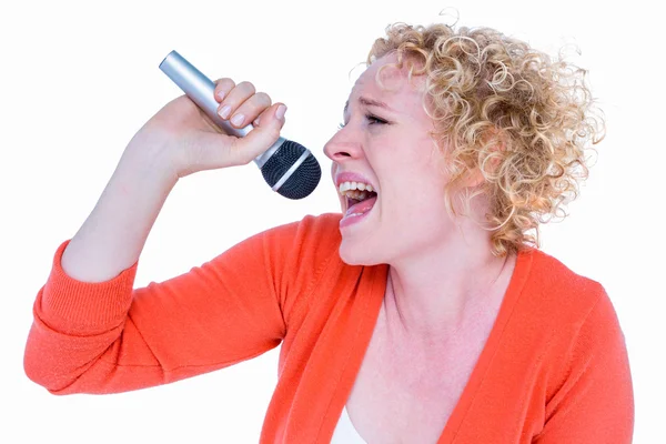 Fröhliche Blondine singt in Mikrofon — Stockfoto