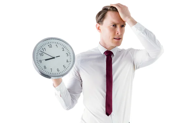 Anxious businessman holding a clock — Stock Photo, Image