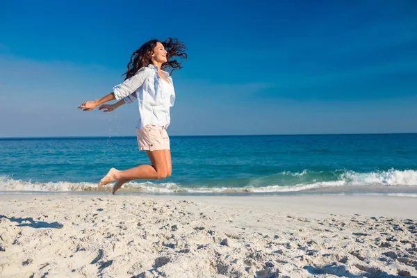 Mujer feliz saltando en la playa — Foto de Stock