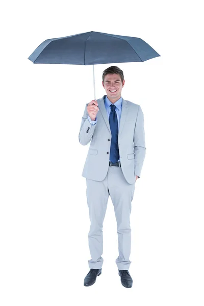 Empresário olhando para a câmera sob guarda-chuva — Fotografia de Stock