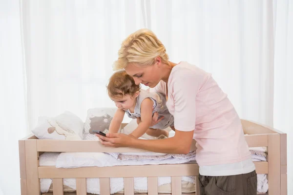 Blonde woman with son using phone — Stockfoto