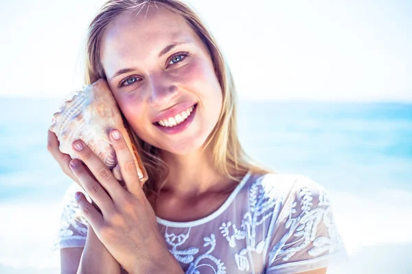 Lovely woman listening to shell — Stock Photo, Image