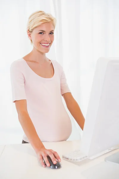 Bionda incinta usando il computer — Foto Stock