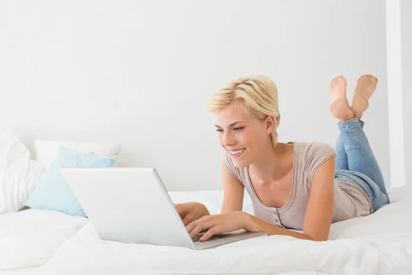 Donna sorridente utilizzando il computer portatile — Foto Stock