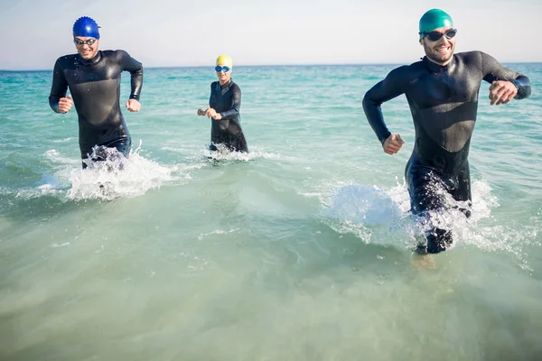 Nadadores corriendo en el océano — Foto de Stock