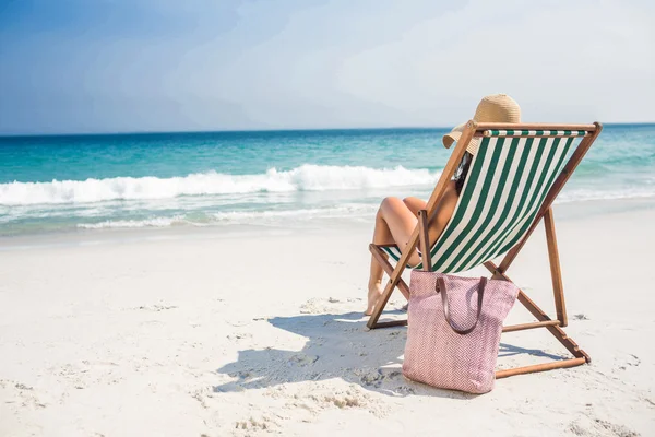 Rückansicht der hübschen Brünette entspannt auf Liegestuhl am Strand — Stockfoto