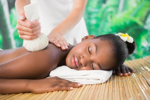 Woman enjoying herbal compress massage — Stock Photo, Image