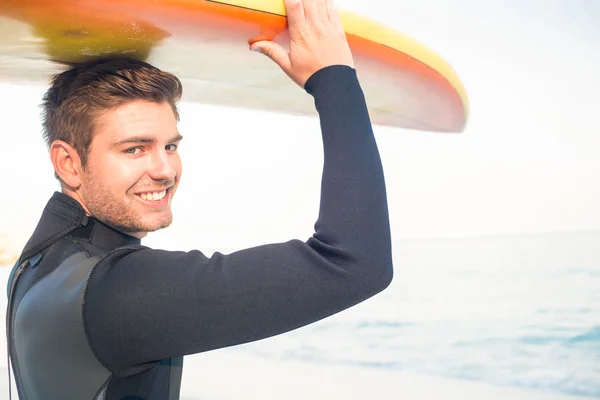 Человек в гидрокостюме с доской для серфинга в солнечный день — стоковое фото