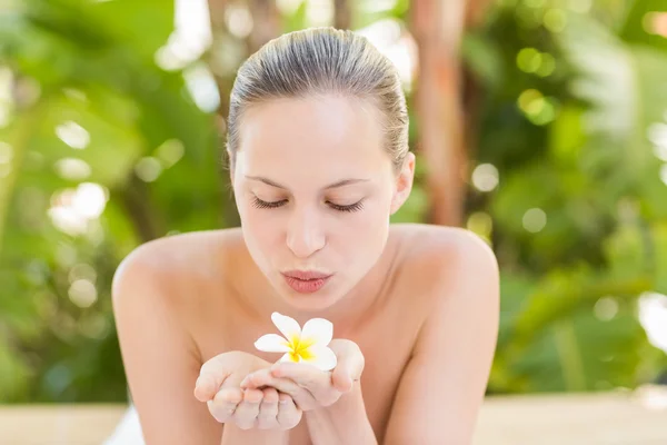 Bionda che soffia sul fiore al centro benessere — Foto Stock