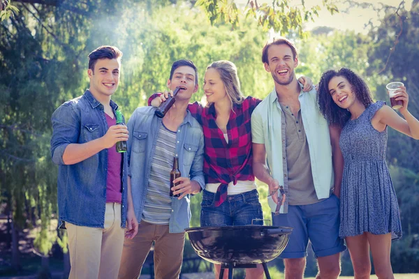 Amigos felizes no parque fazendo churrasco — Fotografia de Stock