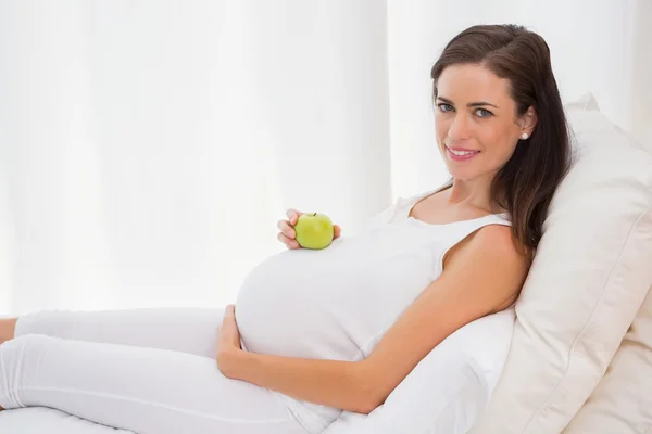 Pregnancy with an apple on belly — Stockfoto