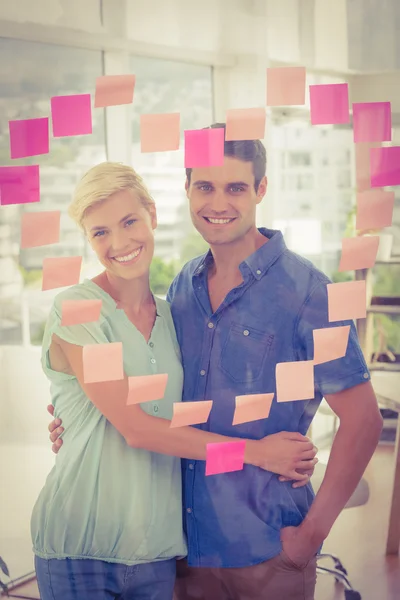 Business partners posing in front of pink heart posts it — Stock Photo, Image