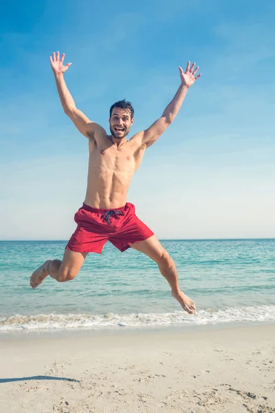 Lycklig man hoppa på stranden — Stockfoto