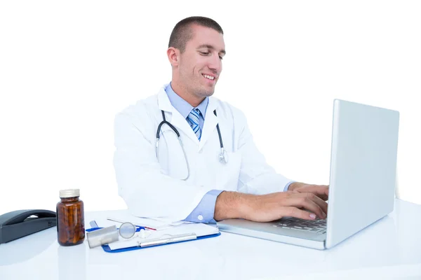 Médico sorridente trabalhando em seu laptop — Fotografia de Stock