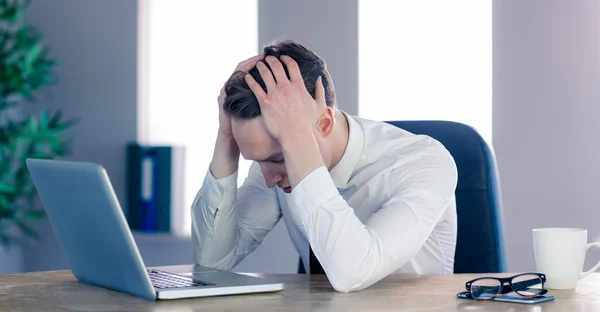 Zakenman met hoofd in handen van streek — Stockfoto