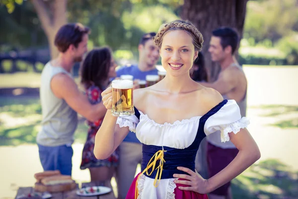 Schöne Oktoberfest-Blondine prostet im Park zu — Stockfoto