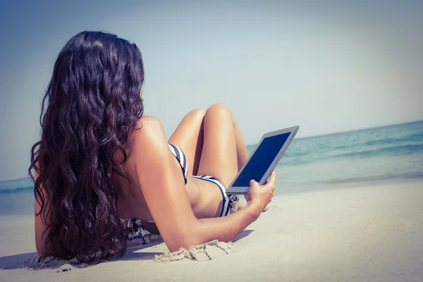 Brunette gebruiken, tablet pc op strand — Stockfoto