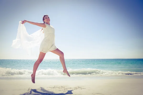 Friedliche Brünette springt am Strand — Stockfoto