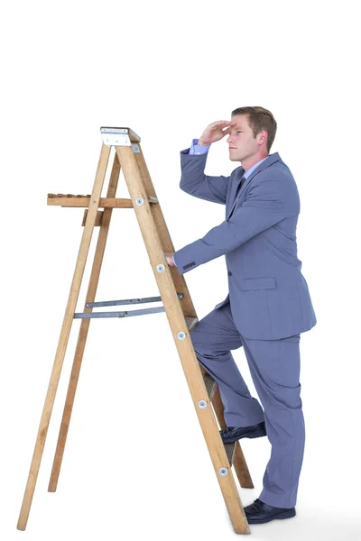 Бизнесмен, стоящий на лестнице и смотрящий — стоковое фото