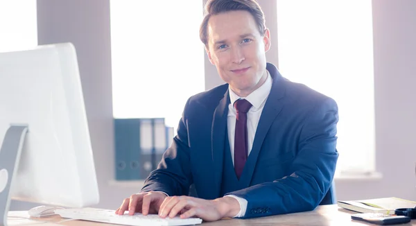 Sonriente hombre de negocios escribiendo en el portátil — Foto de Stock