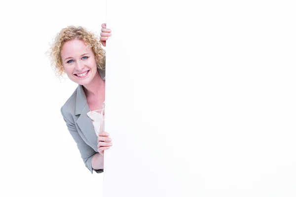 Woman looking around blank sign — Stock Photo, Image