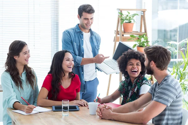 Jungunternehmer zeigt Kollegen seinen Laptop — Stockfoto